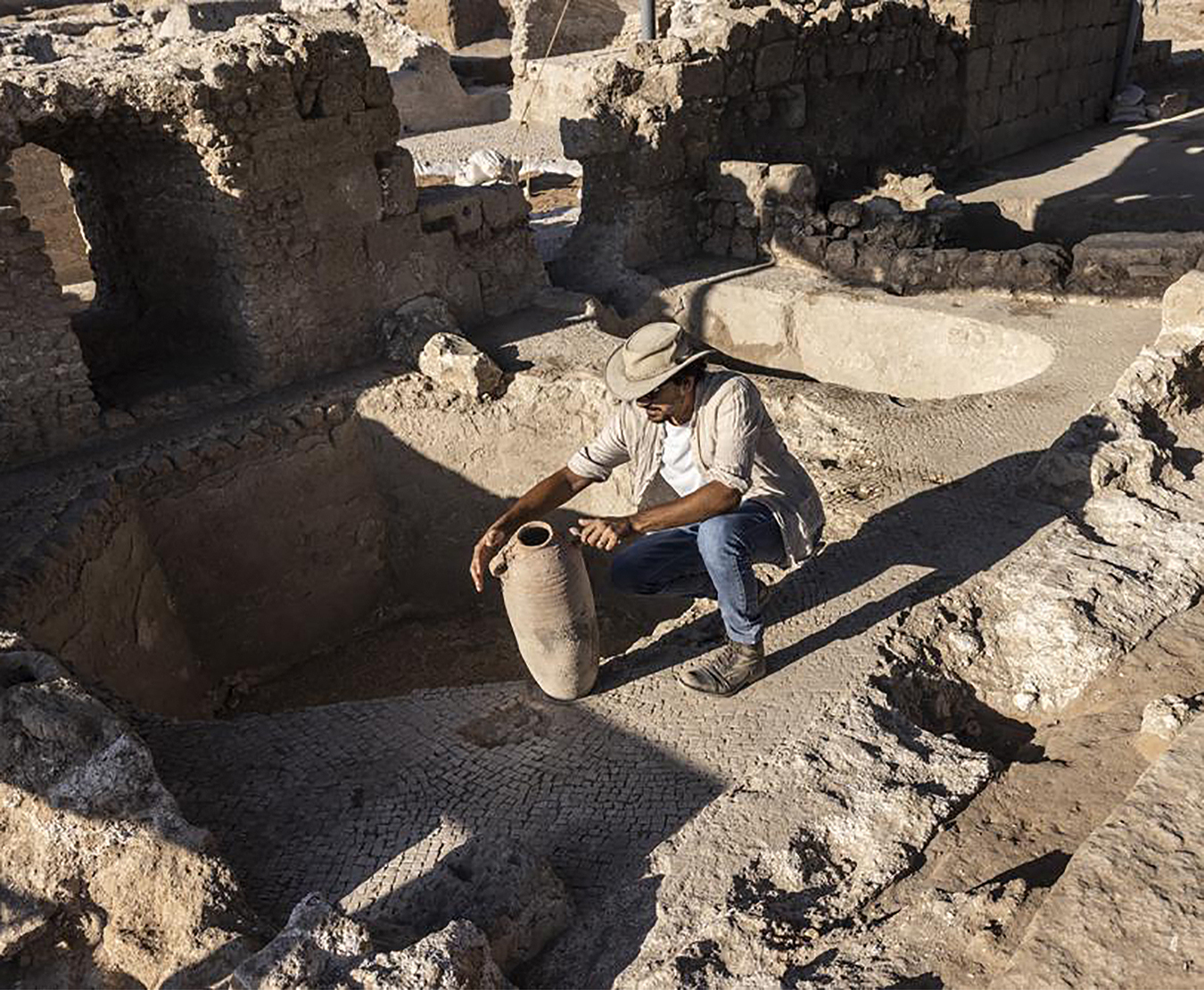 Avshalom Davidesko, from the Israel's Antiquities Authority, examines a jar in a massive ancient winemaking complex dating back some 1,500 years in Yavne, south of Tel Aviv, Israel. Tsafrir Abayov/AP