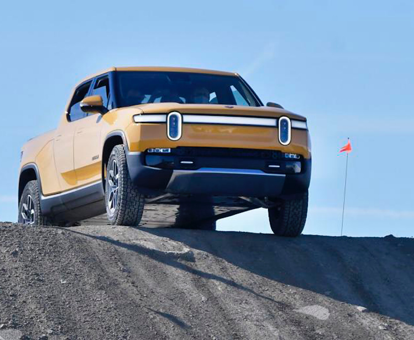 A Rivian R1T pickup truck goes over the side of a 45-degree embankment on a test track at the Normal automotive plant on Sunday, Sept. 26, 2021.